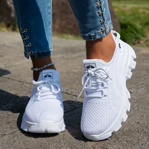 Primer plano de zapatillas blancas de punto transpirable con suelas de goma