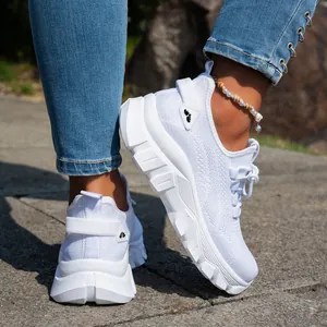 Primer plano de zapatillas de running blancas de malla transpirable para mujeres