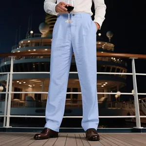 Pantalon en lin bleu clair pour homme porté par un mannequin sur un pont de croisière.