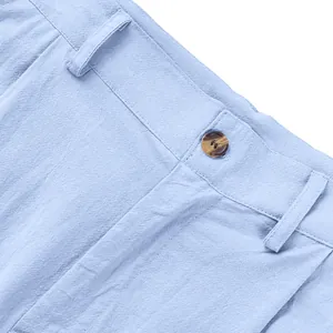 Gros plan de la taille d'un pantalon décontracté en lin bleu clair avec détail de bouton