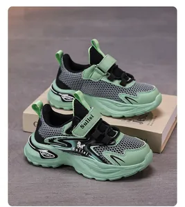 Close-up of green and black breathable mesh boys' athletic running shoes on a book