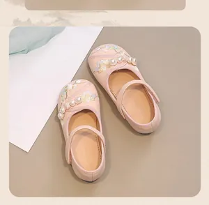 Detail view of pink girl's princess shoes with elegant floral embroidery and pearls