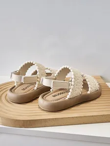 Vista detallada de sandalias étnicas para niñas con correas tejidas