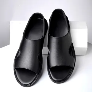 Close-up view of black pebble-grain leather men's sandals on white display blocks.