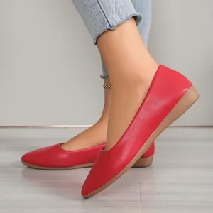 Detail shot of elegant red pointed-toe flat shoes featuring a textured leather finish