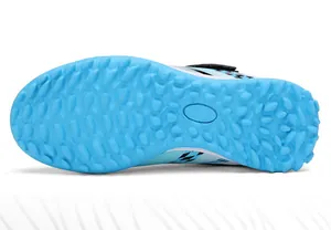 Vue de la semelle des chaussures de football TF bleues pour enfants avec crampons