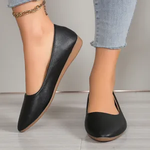 Close-up of elegant black pointed-toe flat shoes featuring high-quality textured leather finish