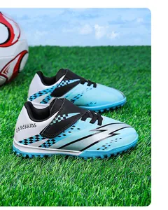 Gros plan de chaussures de football pour enfants à scratch sur l'herbe verte