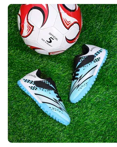 Chaussures de foot enfant bleues à scratch avec ballon de foot sur gazon synthétique