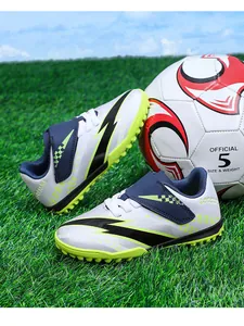 Chaussures de football pour enfants avec scratchs sur un terrain en gazon synthétique