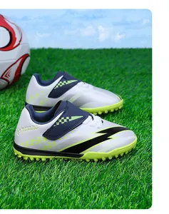 Gros plan de chaussures de football pour enfants avec scratch sur gazon vert professionnel