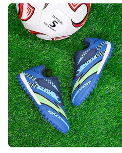Vue détaillée de chaussures de football pour enfants avec scratch sur gazon artificiel