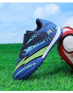 Gros plan d'une chaussure de foot enfant bleue avec motif éclair et bande velcro