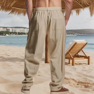 Back view of men's loose khaki linen casual pants showing pocket detail on a beach scene