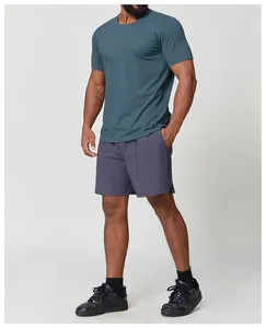 Professional model wearing a teal quick-dry sports t-shirt and grey shorts for gym or hiking