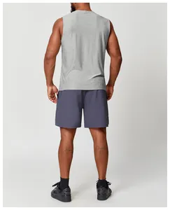 Rückansicht eines Mannes im grauen atmungsaktiven Sport-Trägershirt und lila Shorts.