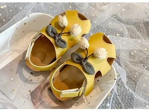 Detailansicht gelber Kleinkindersandalen mit Tulpen- und Schleifendekor