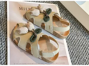 Nahaufnahme von Mädchen-Sandalen in Salbeigrün mit karierten Tulpen-Dekorationen