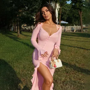 Elegant pink long sleeve V-neck ruffled dress with high slit on model in garden setting