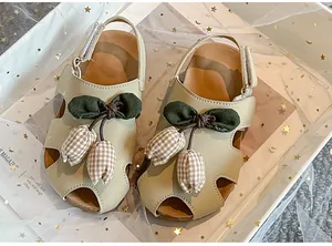 Nahaufnahme von beige Kleinkind-Sandalen mit süßen Tulpendekorationen