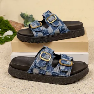 Close-up detail of women's frayed denim checkered platform sandals with gold buckles