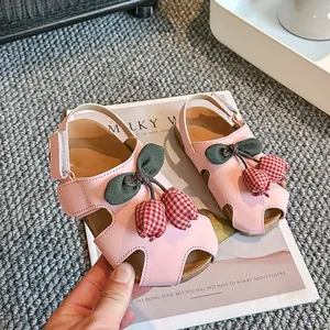 Süße rosa geschlossene Sandalen für Mädchen mit Tulpendekor auf grauem Teppichboden.