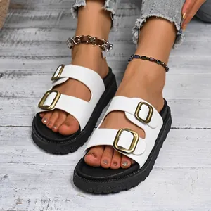 Detailed macro view of white platform sandals featuring double gold-tone buckle straps