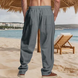 Rear detail view of men's grey vertical striped linen casual pants in a beach setting