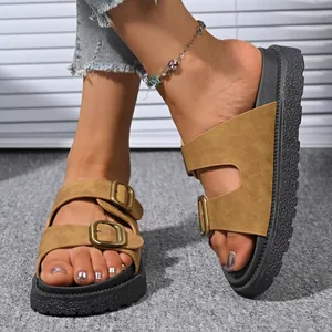 Close-up of women's platform slide sandals with double buckle straps in tan suede