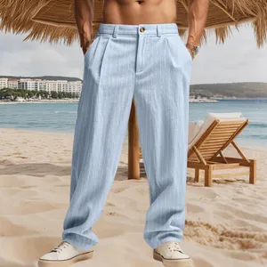 Detailed view of men's light blue striped linen trousers on a sunny beach