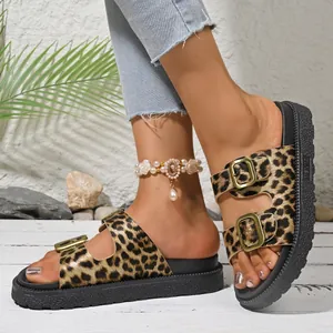 Close-up of leopard print platform sandals with gold buckles on model's feet