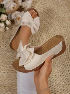 Elegant cream platform sandals with oversized glittery bows for beach vacation