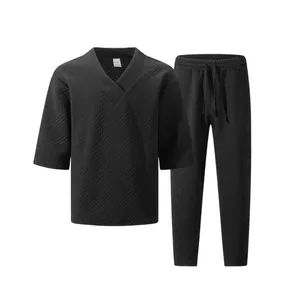 Detail view of men's black textured jacquard V-neck top and matching drawstring pants set