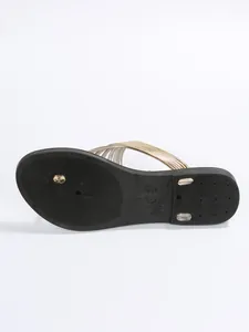 Detailansicht der rutschfesten Sohle und der goldenen Riemen von Damen-Flip-Flops