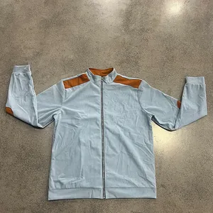 Detail shot of light blue ribbed zip-up jacket with brown shoulder and elbow patches