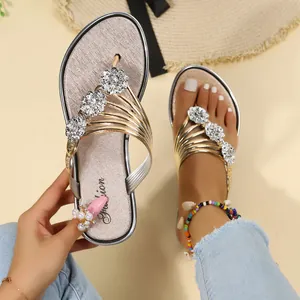 Vista detallada de sandalias doradas para mujer con elegantes flores brillantes