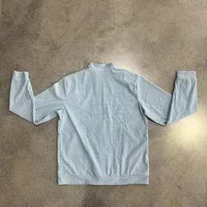 Detailed back view of a heavy light blue ribbed corduroy jacket with stand collar