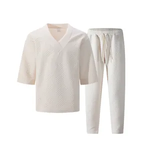 Macro detail of men's cream V-neck set showing the intricate geometric jacquard texture