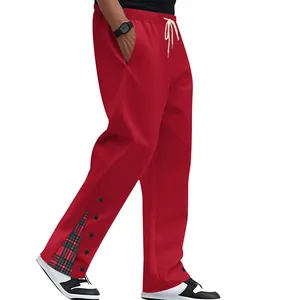 Dettaglio ravvicinato dei pantaloni rossi con accenti scozzesi e bottoni laterali.