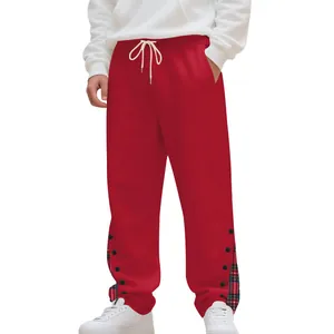 Dettaglio di pantaloni jogger rossi da uomo con bordo scozzese e bottoni.