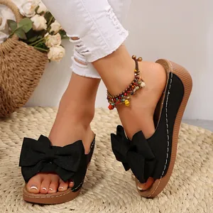 Women's black wedge slides with large bow detail, perfect for summer beach vacations