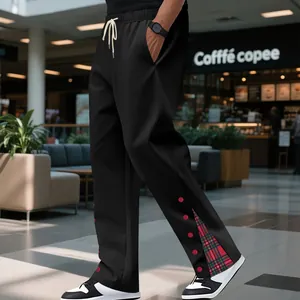 Dettaglio dei pantaloni sportivi neri da uomo con inserto a quadri rossi e coulisse