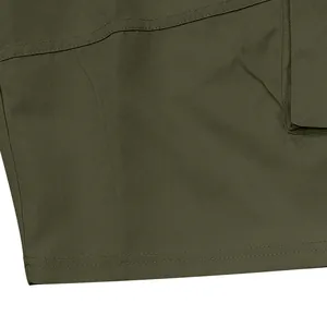 Detailed close-up of olive green twill fabric and double stitching on men's cargo shorts.