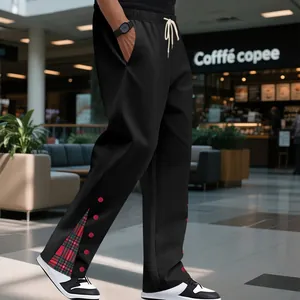 Dettaglio dei pantaloni sportivi pesanti neri da uomo con spacco scozzese e bottoni