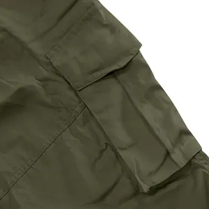 Close-up detail of olive green men's cargo shorts pocket showing durable twill fabric