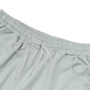 Close-up detail of light grey men's cargo shorts featuring elastic waistband and drawstring