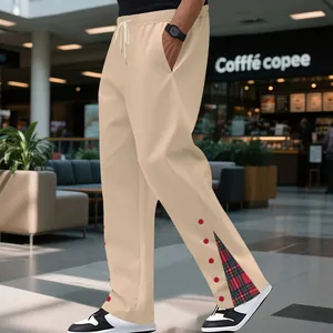 Dettaglio dei pantaloni beige da uomo con orlo a spacco e inserto in tessuto scozzese