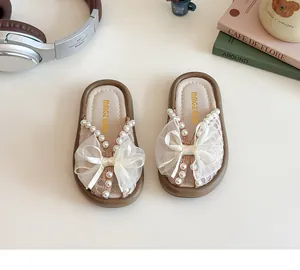 Vista detallada de zapatillas de princesa para niños con lazo de encaje blanco y perlas