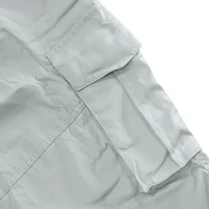 Detail shot of a large side cargo pocket on light grey shorts, showing stitching.