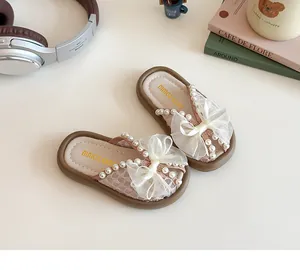 Vista superior de pantuflas rosas para niños con lazo de encaje y perlas elegantes